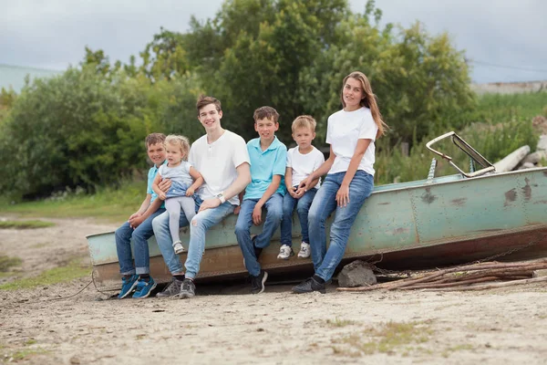 Groupe de joyeux joyeux beaux enfants assis sur l'herbe dans le parc, en plein air , — Photo