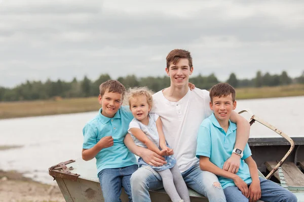 Grupo de felices y alegres hermosos niños sentados en el barco en el parque, al aire libre — Foto de Stock