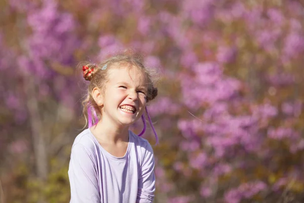 Πορτρέτο Ενός Χαρούμενου Μικρού Κοριτσιού Μωβ Φόρεμα Φόντο Ανθισμένων Μοβ — Φωτογραφία Αρχείου