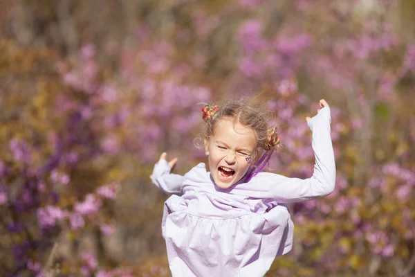 Портрет Щасливої Веселої Маленької Дівчинки Фіолетовій Сукні Фоні Квітучих Фіолетових — стокове фото