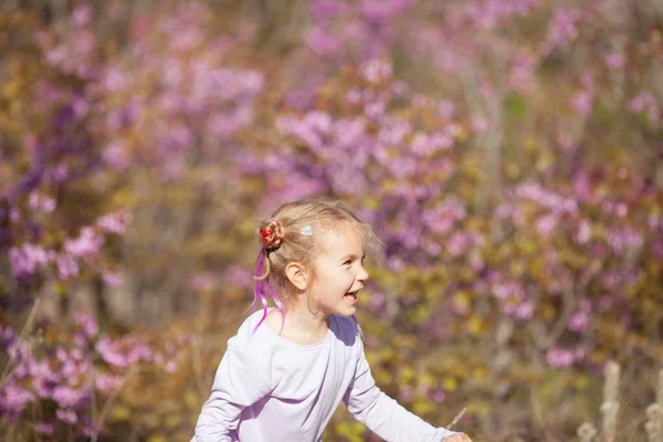 Портрет Щасливої Веселої Маленької Дівчинки Фіолетовій Сукні Фоні Квітучих Фіолетових — стокове фото