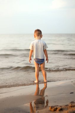 Mutlu çocuk denize sıfır plaj yaz oynarken. Denizde duran çocuk