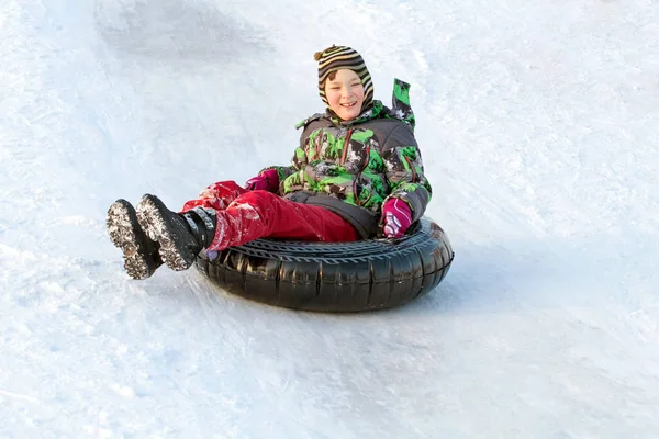 快乐的男孩与雪管 冬天的乐趣 在雪管上滑下山 — 图库照片