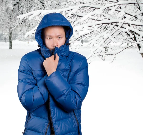 Sorgliga Asiatiska Mannen Blå Vadderad Dunkappa Mot Snörik Vinter Bakgrund — Stockfoto