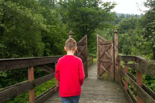 少年が新しい生活にゲートを通って行く — ストック写真