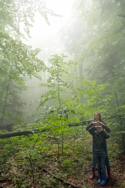 母亲和儿子在神秘的绿色雾蒙蒙的森林 — 图库照片