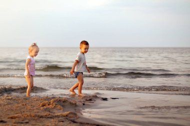 Mutlu aile erkek ve kız kardeşi sahilde oynarken