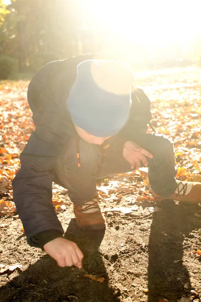 Boy is writing something on the ground — Stock Photo, Image