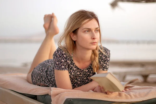 Kvinna läser bok på stranden — Stockfoto