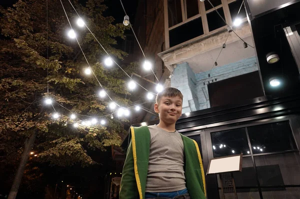 Glücklich Lächelnder Junge Der Draußen Der Nächtlichen Straße Mit Den — Stockfoto