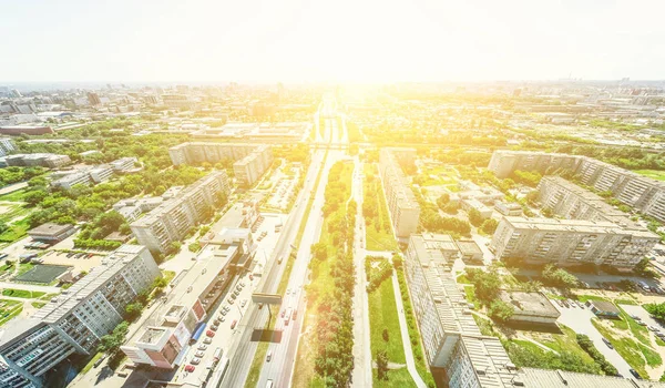 Vista aérea de la ciudad con encrucijadas y caminos, casas, edificios, parques y estacionamientos. Imagen panorámica soleada de verano — Foto de Stock