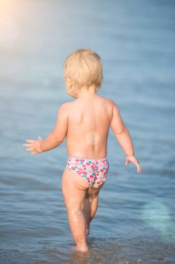 Şirin Bebek kumlu plajı ve deniz suyu oynarken.