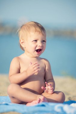 Şirin Bebek denize yakın kum plajındaki oyuncaklar ile oynama.