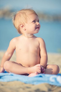 Şirin Bebek denize yakın kum plajındaki oyuncaklar ile oynama.