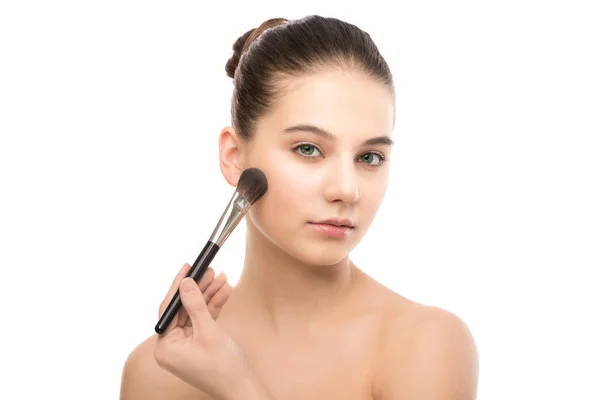 Jonge brunette vrouw met schoon gezicht. Perfecte huid meisje cosmetische penseel toe te passen. Geïsoleerd op een witte. — Stockfoto