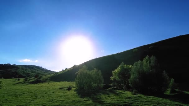 4K UHD fjälläng timelapse på sommaren. Moln, träd, grönt gräs och solstrålar rörelse. — Stockvideo