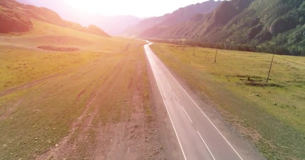 Vuelo sobre carretera asfaltada montaña carretera y prado — Vídeo de stock