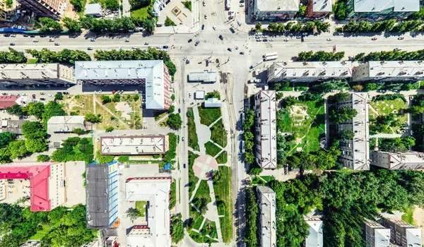 Aerial city view with crossroads and roads, houses, buildings, parks and parking lots. Sunny summer panoramic image — Stock Photo, Image