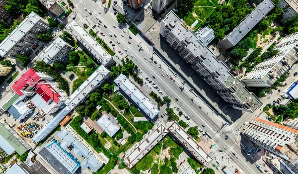 Vista aérea de la ciudad con encrucijadas y caminos, casas, edificios, parques y estacionamientos. Imagen panorámica soleada de verano — Foto de Stock