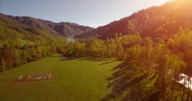 Güneşli yaz sabahında taze dağ nehri ve çayır üzerinde uçuşun ortasında. Aşağıdaki kırsal toprak yol.