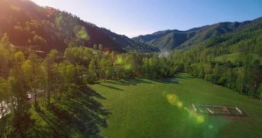 Güneşli yaz sabahında taze dağ nehri ve çayır üzerinde uçuşun ortasında. Aşağıdaki kırsal toprak yol.