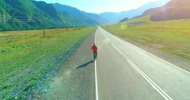 Mükemmel asfalt yol, sportif adamın arkasında alçak irtifa uçuş