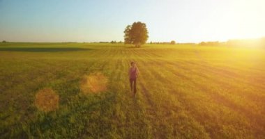UHD 4k havadan görünümü. Alçak irtifa uçuş kırsal alan, sportif kadının önünde