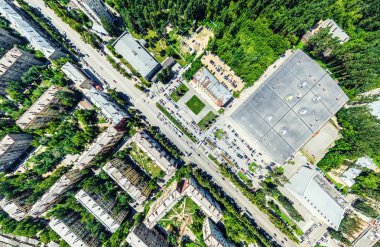 Kesişen yollar, evler, binalar, parklar ve otoparklar olan havacılık şehri manzarası. Güneşli yaz panoramik resmi