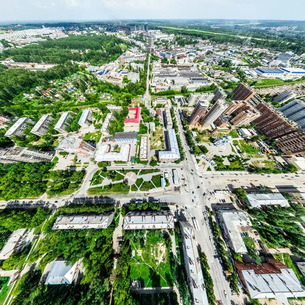 Vista aérea de la ciudad con encrucijadas y caminos, casas, edificios, parques y estacionamientos. Imagen panorámica soleada de verano — Foto de Stock