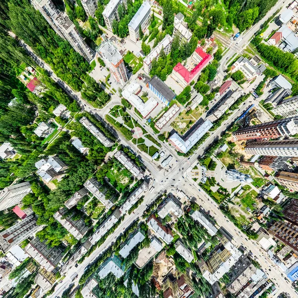 Vista aérea de la ciudad con encrucijadas y caminos, casas, edificios, parques y estacionamientos. Imagen panorámica soleada de verano —  Fotos de Stock