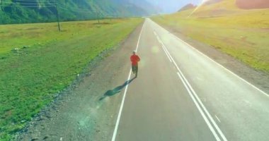 Mükemmel asfalt yolda sporcunun önünde alçak irtifa uçuşu.