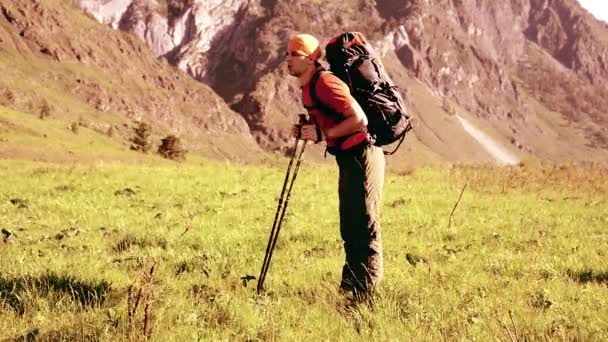 Senderismo hombre caminando en el prado de montaña verde con mochila. Verano deporte y recreación concepto . — Vídeo de stock