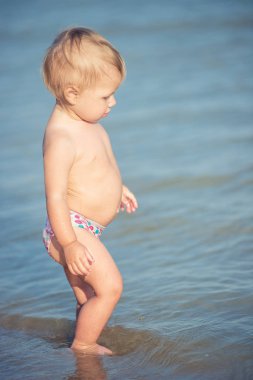 Şirin Bebek kumlu plajı ve deniz suyu oynarken.