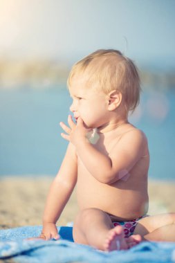 Şirin Bebek denize yakın kum plajındaki oyuncaklar ile oynama.