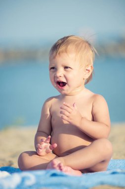 Şirin Bebek denize yakın kum plajındaki oyuncaklar ile oynama.