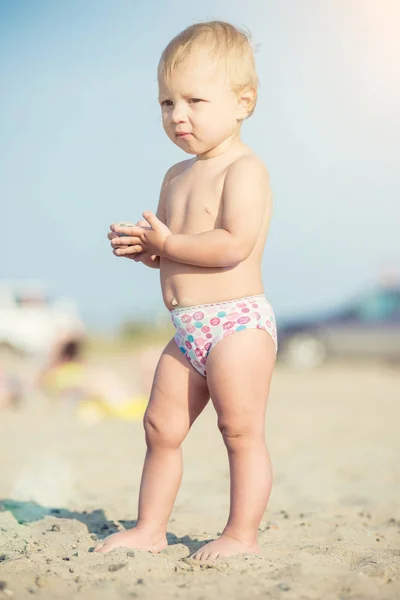 Carino bambino che gioca con i giocattoli sulla spiaggia di sabbia vicino al mare . — Foto Stock