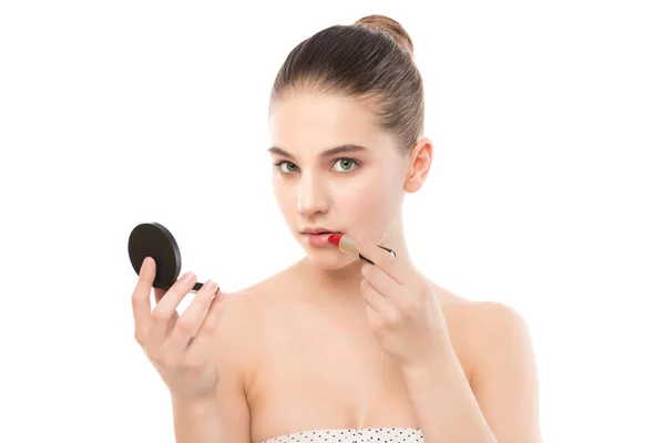 Ung brunett kvinna med perfekt rena ansikte om läppstift med spegel. Isolerad på en vit. — Stockfoto