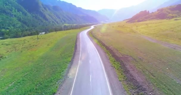 Vuelo sobre carretera asfaltada montaña carretera y prado — Vídeo de stock