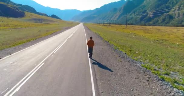 Vol à basse altitude devant un sportif sur une route asphaltée parfaite — Video