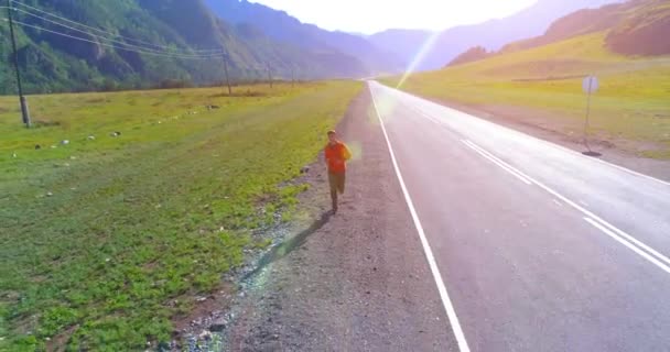 Vuelo de baja altitud frente al deportista en el camino perfecto de asfalto — Vídeo de stock