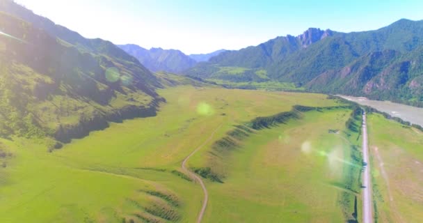 Aerea strada di montagna rurale e prato al sole mattina d'estate. Autostrada asfaltata e fiume. — Video Stock