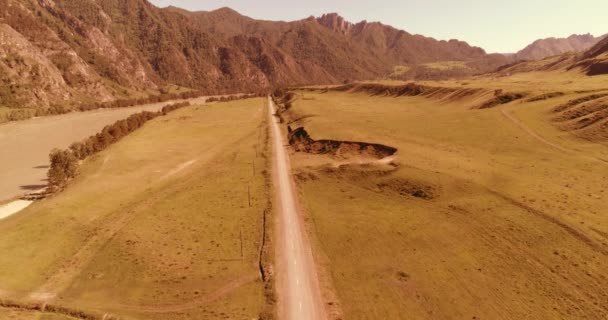 日当たりの良い夏の朝に空中農村部の山岳道路や牧草地。アスファルトハイウェイと川. — ストック動画