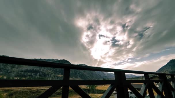 Timelapse van houten hek op hoog terras bij berglandschap met wolken. Horizontale schuifbeweging — Stockvideo