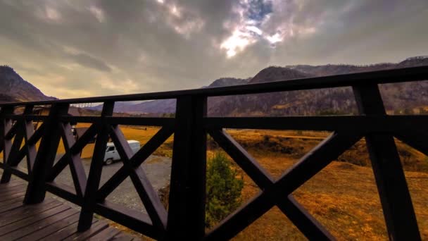 Timelapse van houten hek op hoog terras bij berglandschap met wolken. Horizontale schuifbeweging — Stockvideo