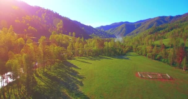 Mid air flygning över färska berg flod och äng på solig sommarmorgon. Landsbygdsvägen nedanför. — Stockvideo