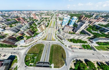 Kesişen yollar, evler, binalar, parklar ve otoparklar olan havacılık şehri manzarası. Güneşli yaz panoramik resmi