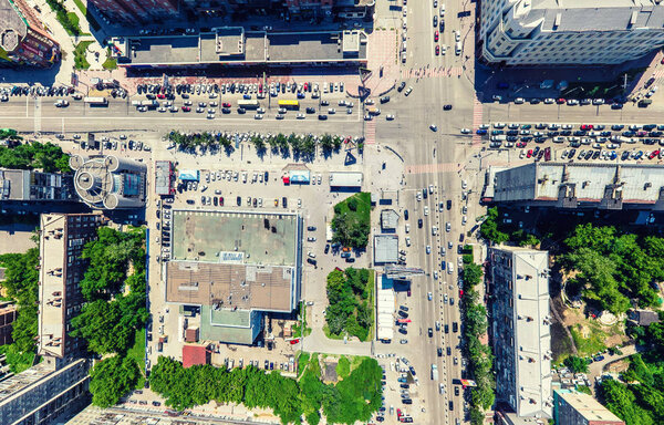 Aerial city view with crossroads and roads, houses, buildings, parks and parking lots, bridges. Urban landscape. Copter shot. Panoramic image.