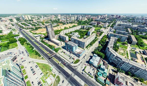 Kesişen yollar, evler, binalar, parklar ve otoparklar olan havacılık şehri manzarası. Güneşli yaz panoramik resmi