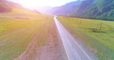 Dağda asfalt karayolu ve çayır üzerinde uçuş