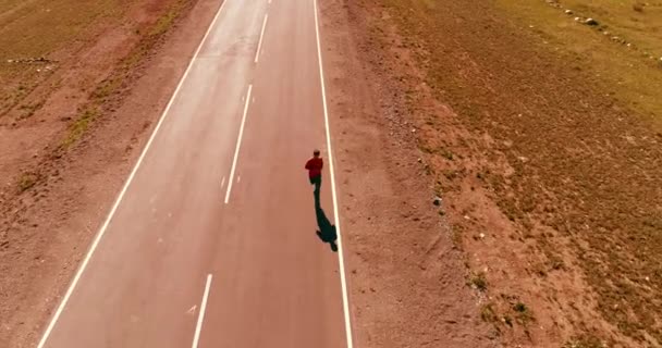 Vôo de baixa altitude sobre homem desportivo em nova estrada de asfalto — Vídeo de Stock